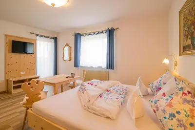 a small room with a bed and a table at Garni Stübele in Tirolo