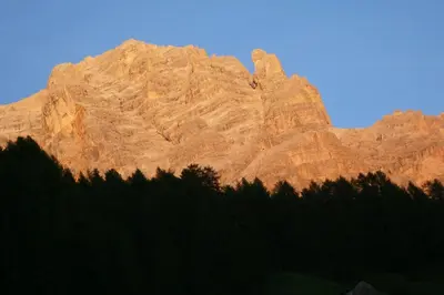a mountain with a house in the middle of a field at Garni Jasmin in San Cassiano