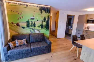 a living room with a couch and a painting on the wall at Mair am Anger-Appartments in Riscone