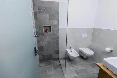 a bathroom with a shower and a toilet and a sink at Mair am Anger-Appartments in Riscone