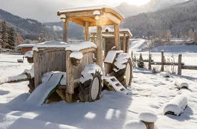 a wooden playground in the snow with a wooden tower at Alpenvilla Large Family Apartment - by Familiaris- Pools 500 meters in Valdaora