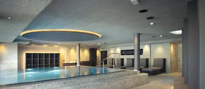 a swimming pool in a building with a large ceiling at Alpenvilla Large Family Apartment - by Familiaris- Pools 500 meters in Valdaora