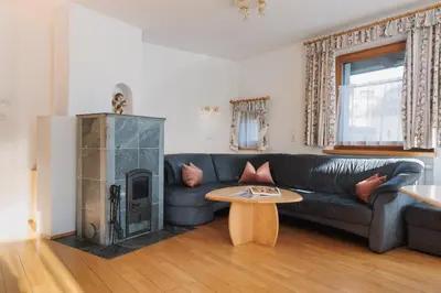 a living room with a couch and a fireplace at Alpenvilla Large Family Apartment - by Familiaris- Pools 500 meters in Valdaora