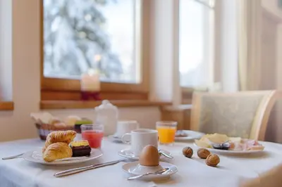 a table with plates of breakfast food on it at Hotel Garni Elisir in Arabba