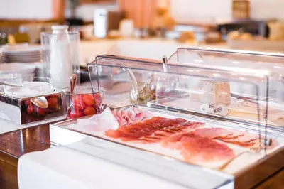 a buffet with meat and other foods on a table at NaturResidence Dolomitenhof in Siusi