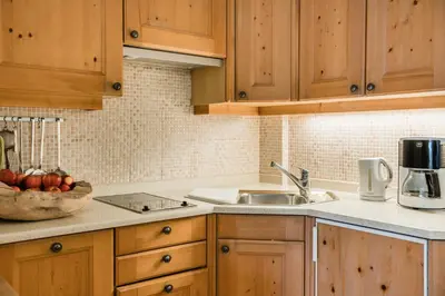a kitchen with wooden cabinets and a sink at NaturResidence Dolomitenhof in Siusi