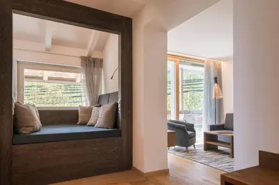 a mirror reflecting a living room with a couch in a room at Appartement KroneLiving in Tirolo