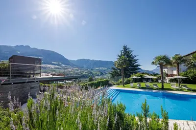 a swimming pool with a view of the mountains at Appartement KroneLiving in Tirolo