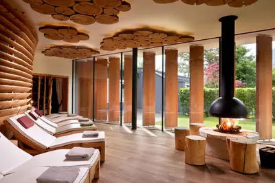 a room with four beds and a fireplace and windows at Engels Park in Vipiteno