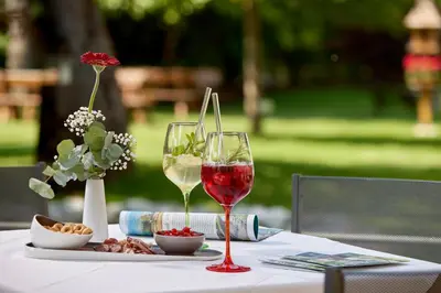 a table with two wine glasses and a plate of food at Engels Park in Vipiteno
