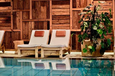 two lounge chairs next to a swimming pool at Engels Park in Vipiteno