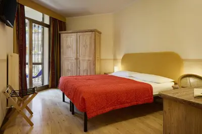 a bedroom with a bed with a red blanket at Hotel Portavescovo in Arabba