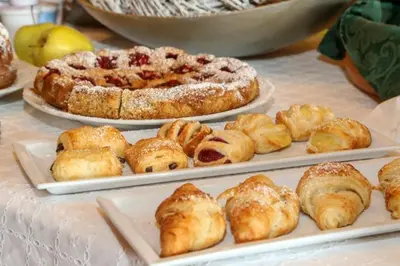 a table with two plates of pastries and a pizza at Ciasa Montanara in La Villa