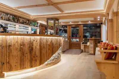 a bar with wooden walls and a wooden counter at Hotel Ciasa Lorenzi in Cortina dʼAmpezzo