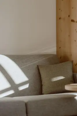 a couch with a pillow in a living room at Garberhof Dolomit Family in Rasùn di Sotto