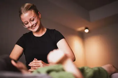 a woman wearing glasses is laughing while sitting at Garberhof Dolomit Family in Rasùn di Sotto