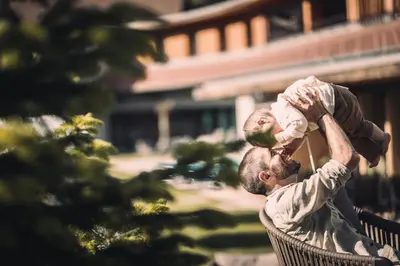 a man holding a baby on his shoulders at Garberhof Dolomit Family in Rasùn di Sotto