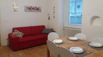 a living room with a red couch and a table at La casa di Cì-CÌ in Merano