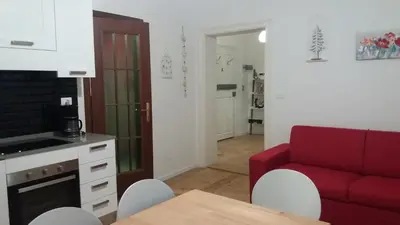 a living room with a red couch and a table at La casa di Cì-CÌ in Merano