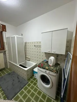 a kitchen with a counter with a tv on the wall at Appartamento San Lucano in Agordo