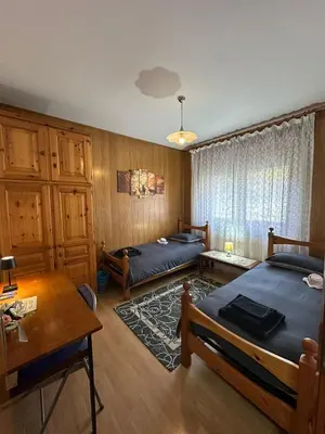 a bedroom with two beds and a table at Appartamento San Lucano in Agordo