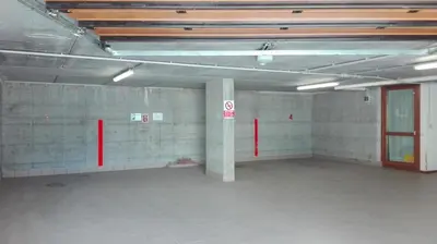 an empty parking garage with a large room with red doors at Residenza Domino in Selva di Cadore