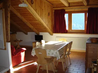 a dining room with a table and chairs in a house at Residenza Domino in Selva di Cadore