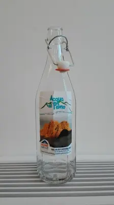 a bottle filled with water sitting on a table at Residenza Domino in Selva di Cadore