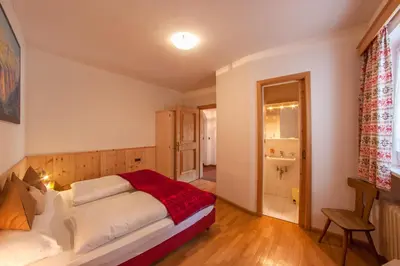 a bedroom with a bed and a bathroom at Apartments Heritage House Margherita in Santa Cristina in Val Gardena