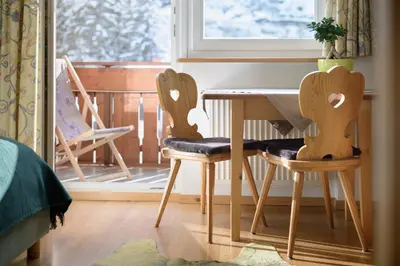 a table and two chairs in a room with a window at Apartments Heritage House Margherita in Santa Cristina in Val Gardena