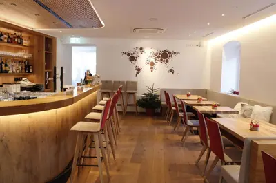 a restaurant with wooden tables and chairs and a bar at Gasthof Zum Hirschen Margreid in Magrè allʼ Adige