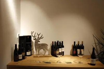 a shelf with wine bottles and a statue of a deer at Gasthof Zum Hirschen Margreid in Magrè allʼ Adige