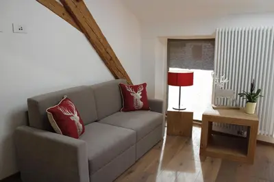 a living room with a couch and a red lamp at Gasthof Zum Hirschen Margreid in Magrè allʼ Adige