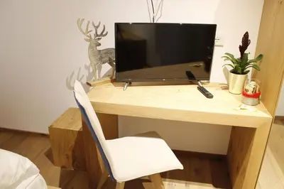 a wooden desk with a television on top of it at Gasthof Zum Hirschen Margreid in Magrè allʼ Adige