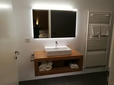 a bathroom with a sink and a mirror and towels at Gasthof Zum Hirschen Margreid in Magrè allʼ Adige