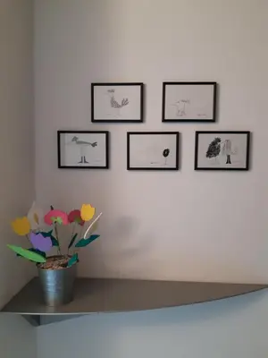 a shelf with a vase of flowers on a wall at EDO in Campitello di Fassa