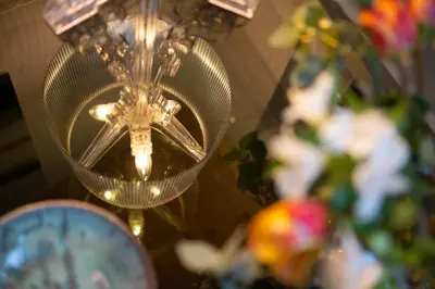 a chandelier in a room with flowers and a clock at EDO in Campitello di Fassa