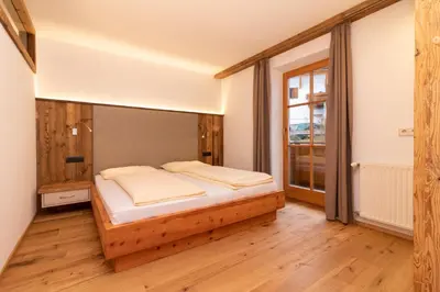 a bedroom with a bed and a large window at Sennerhof in Racines