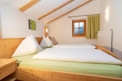 a bedroom with a bed with white sheets and a window at Sennerhof in Racines