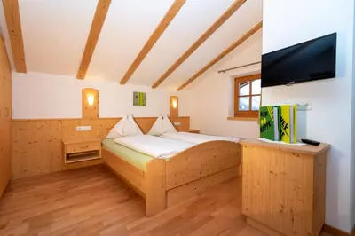 a bedroom with a bed and a flat screen tv at Sennerhof in Racines