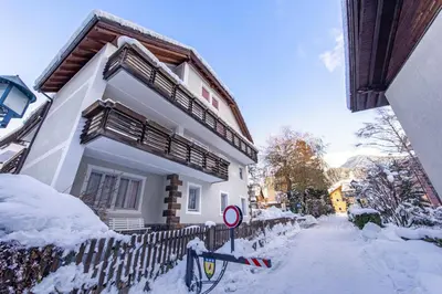 a white house with snow on the side of it at Apartments Jalve in Ortisei