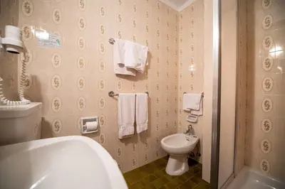 a bathroom with a tub and a toilet and towels at Alara in Bulla