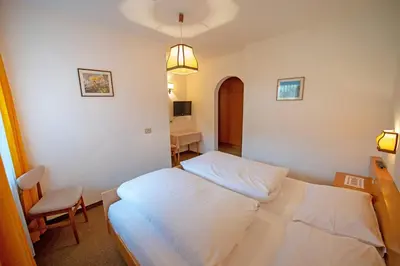 a bedroom with a white bed and a chair at Alara in Bulla