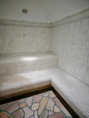 a tiled bench in a bathroom with a tile floor at Villa Flora by AMA Val di Fassa in Canazei