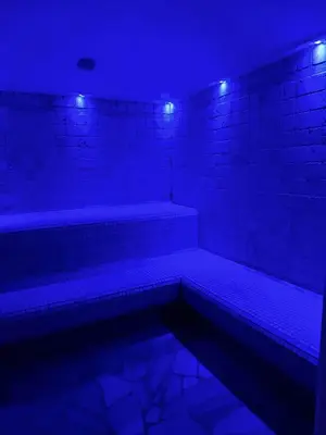 a dark room with blue lights on a brick wall at Villa Flora by AMA Val di Fassa in Canazei