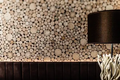 a room with a wall covered in wooden circles at ArtHotel Anterleghes - Gardenahotels in Selva di Val Gardena