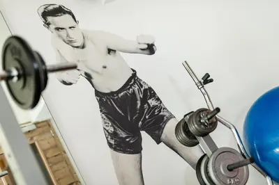 a man lifting a barbell in a gym at ArtHotel Anterleghes - Gardenahotels in Selva di Val Gardena