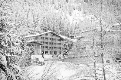a large building in the middle of a snow covered mountain at ArtHotel Anterleghes - Gardenahotels in Selva di Val Gardena