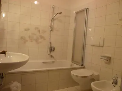 a bathroom with a tub and a toilet and a sink at B&B Hotel Mair am Turm in Tirolo