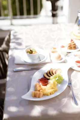 a white table with plates of food on it at B&B Hotel Mair am Turm in Tirolo